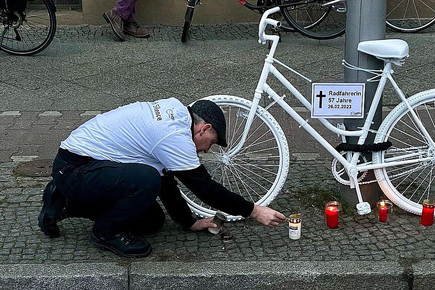 GhostBike Während einer Mahnwache wird eine Kerze an einem GhostBike angezündet