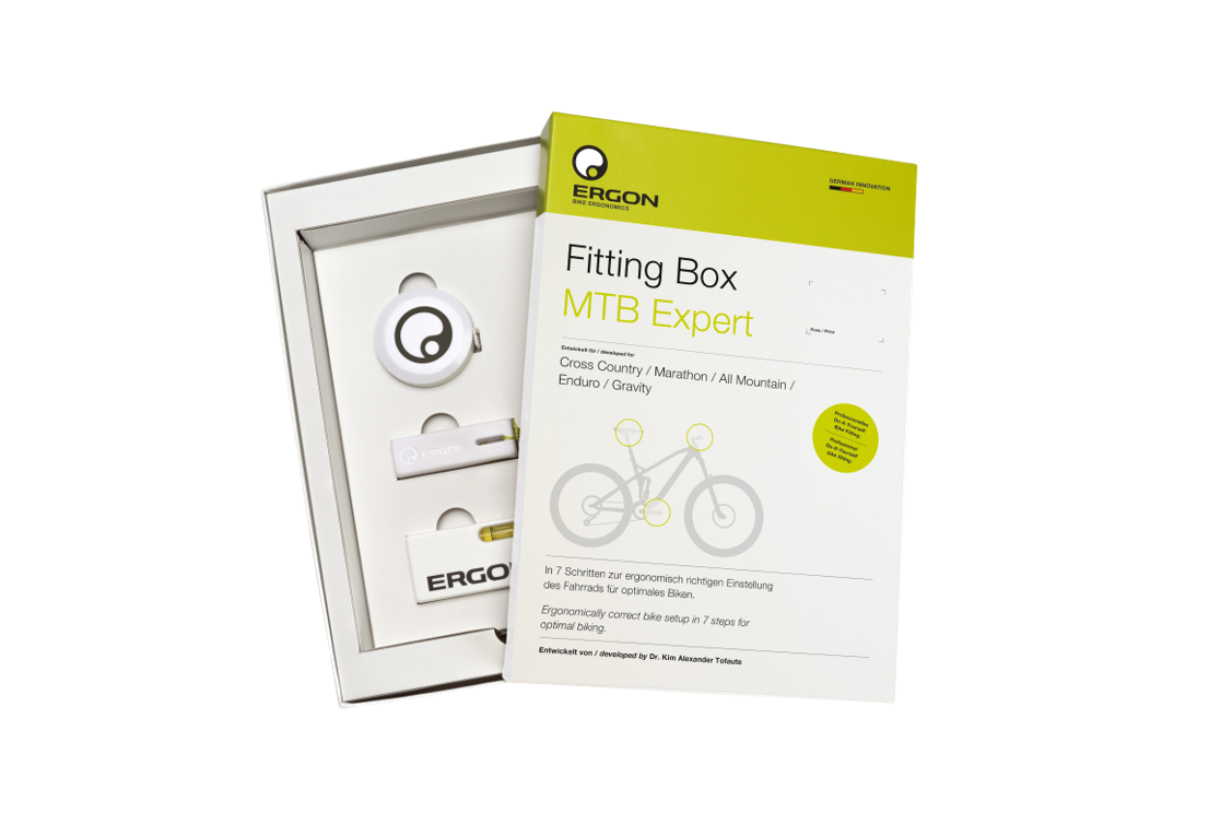 Die ergon Fitting Box, der Deckel ist abgenommen und liegt schräg über dem Karton. Sichtbar sind Schablonen und Maßband und andere Hilfsmittel der Box.