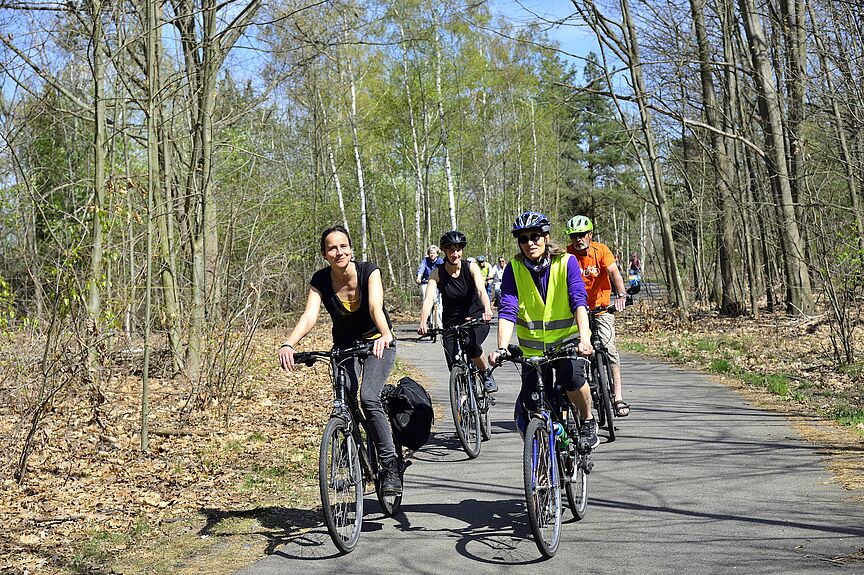 ADFC on tour Eine Gruppe von Radfahrenden zwischen Bäumen