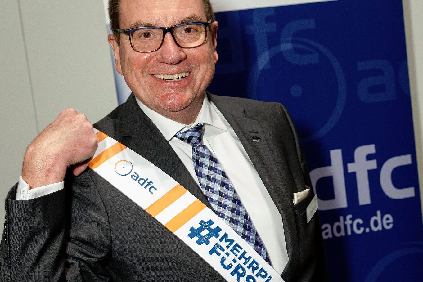 Der ADFC-Bundesvorsitzende Ulrich Syberg hat aus dem Absprerrband der Kampagne MehrPlatzFürsRad eine Schärpe gemacht.gt Der ADFC-Bundesvorsitzende Ulrich Syberg hat aus dem Absprerrband der Kampagne MehrPlatzFürsRad eine Schärpe gemacht.