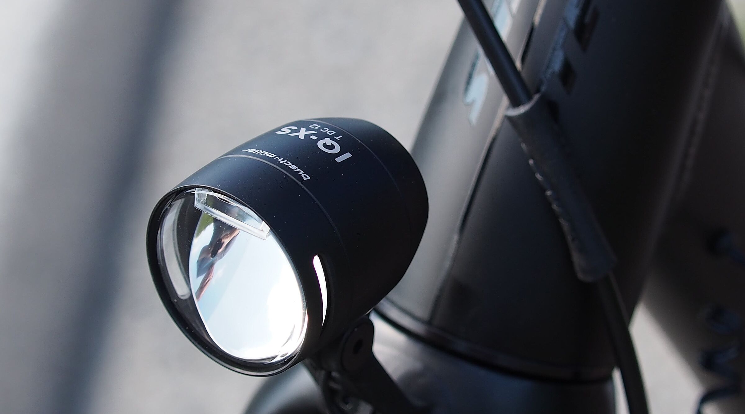 Schwarzer LED-Fahrradscheinwerfer am silbernen Fahrradlenker montiert.