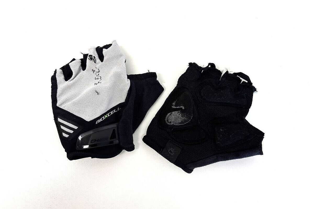 Chiba used Ein paar weiß-schwarze Kurzfinger-Fahrradhandschuhe von Chiba vor weißem Hintergrund.
